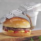 A plastic-looking robot hand serves a plastic-looking burger.